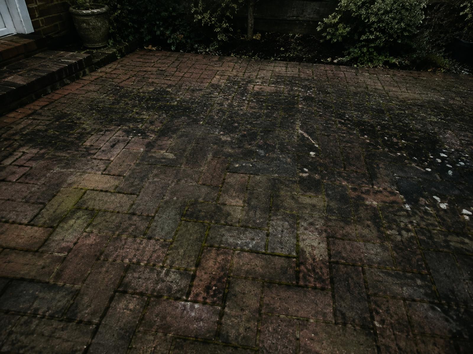 Before: brick paver patio with algae, moss and dark staining